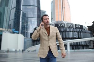 Man walking through downtown office area while talking on phone